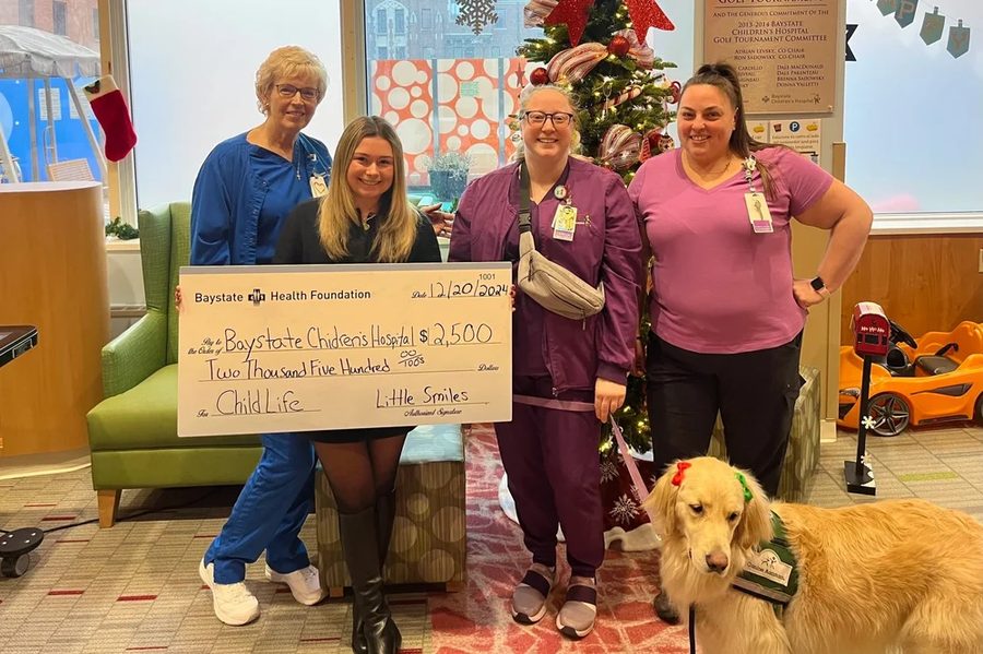 Haley presenting a donation to a hospital Child Life team