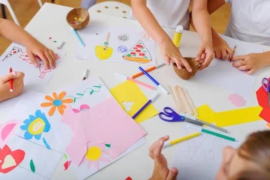 Children making colorful paper crafts together at an activity table